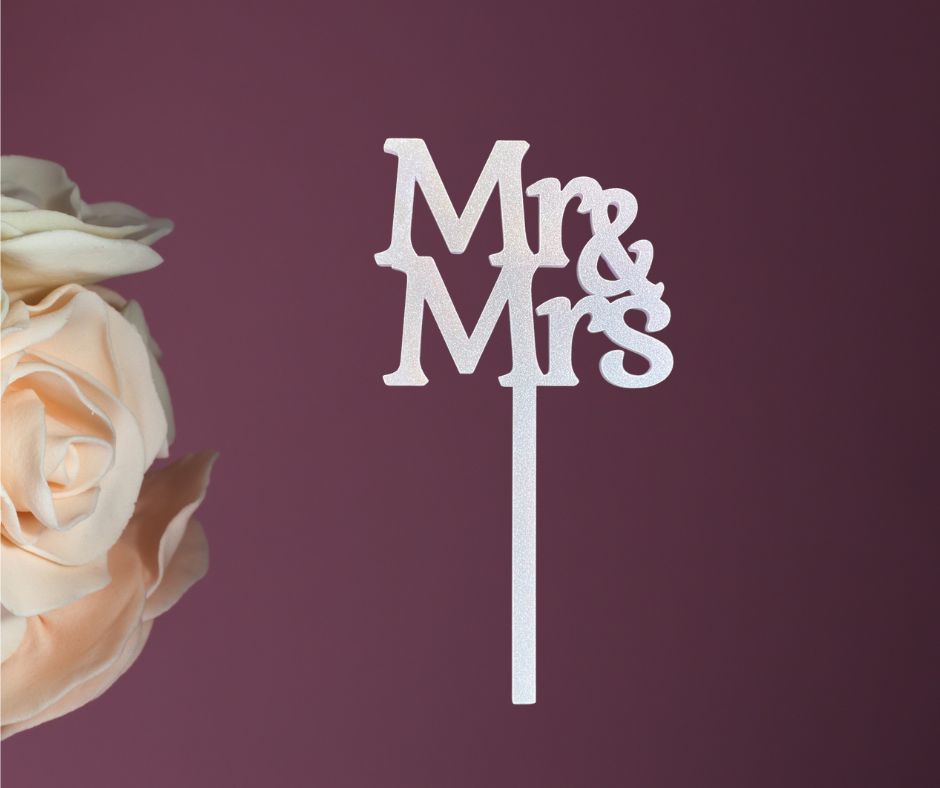 Cake topper with 'Mr & Mrs' on a purple background with a rose.