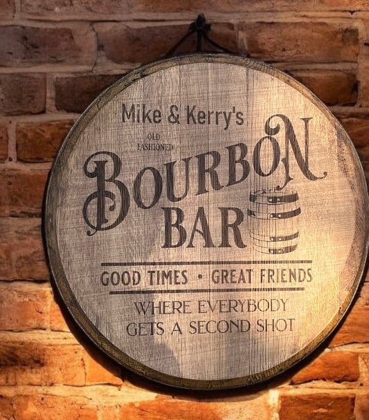 Wooden barrel-shaped sign with 'Bourbon Bar' text on a brick wall background
